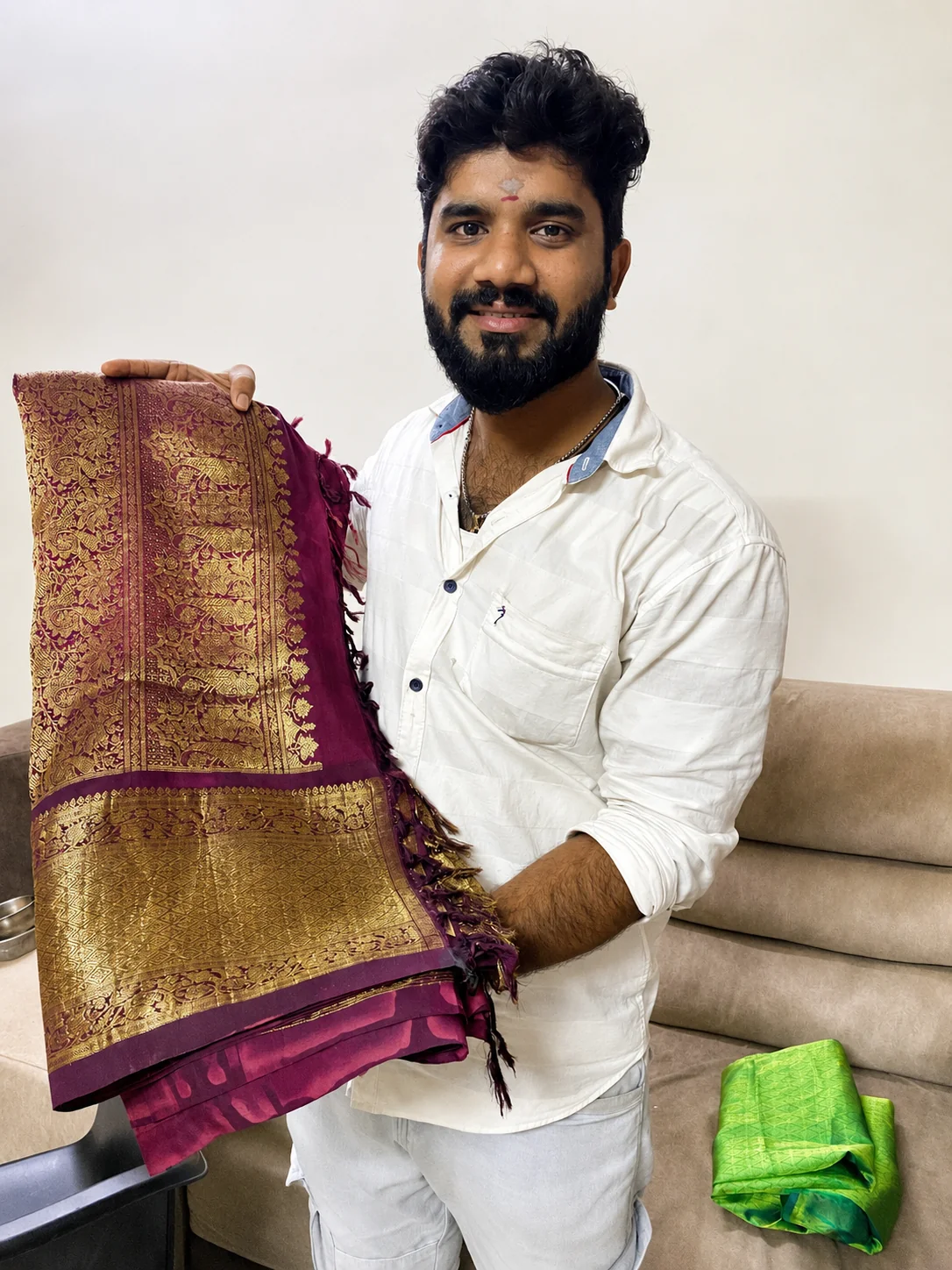 Founder of OM Sairam Pattu Center, trusted old pattu saree buyers in Chennai, holding a purple and gold silk saree