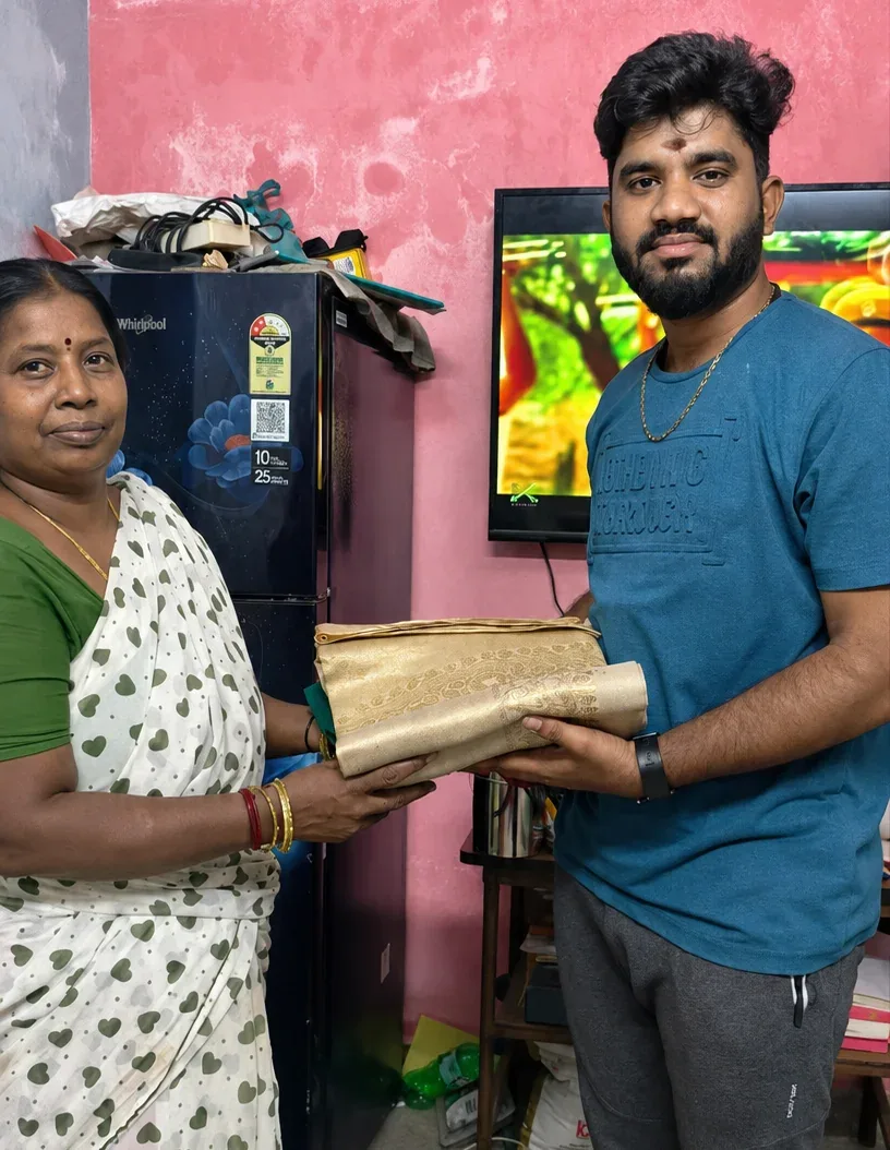 Old silk saree buyers near me — customer handing over a golden silk saree at home