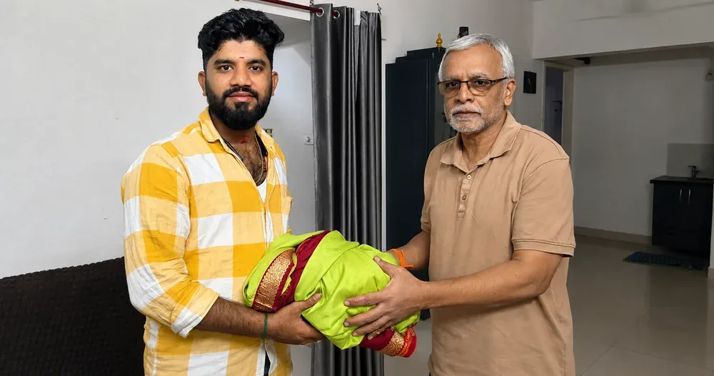 Sell old silk sarees for cash — customer handing over a green and maroon silk saree at home