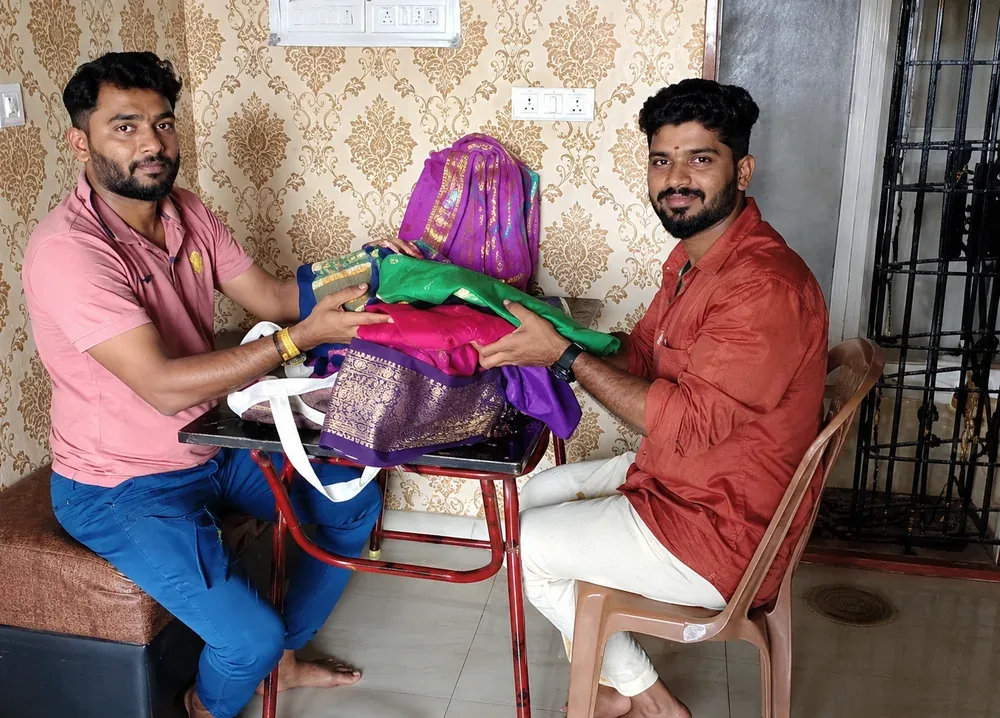 Old silk saree buyers in Chennai — our team reviewing colourful silk sarees with a customer