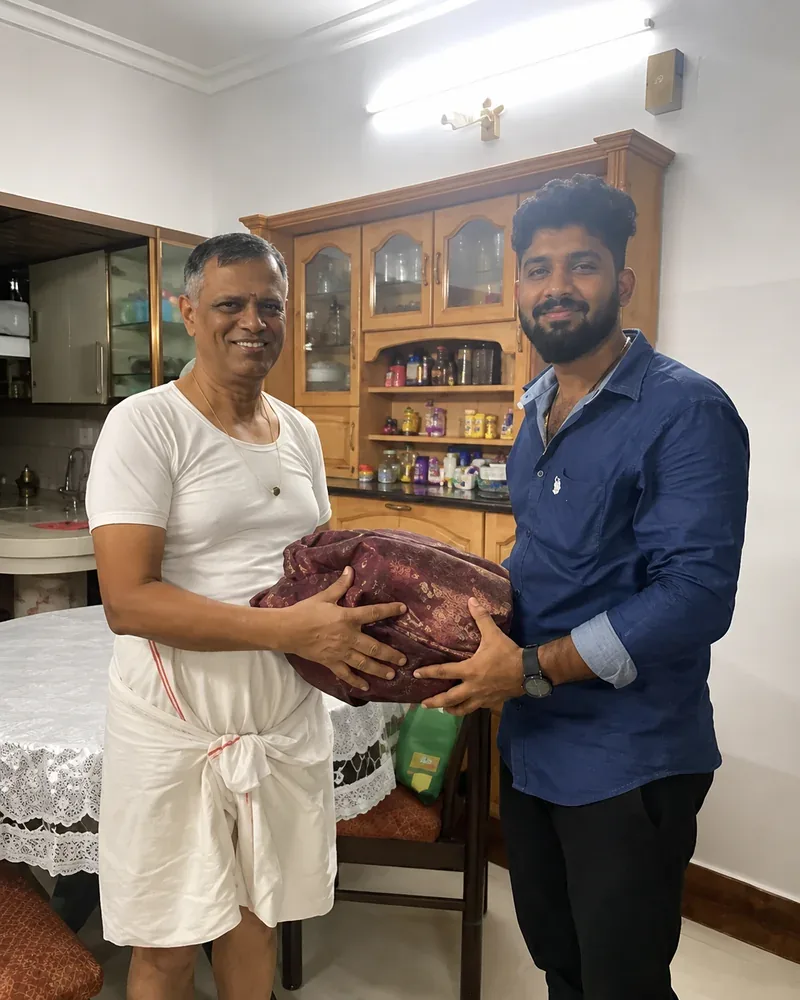 Cash for old silk sarees — customer handing over a maroon silk saree to our team